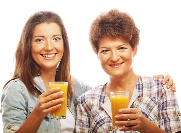 Mature mother and yung daughter with juice — Stock Photo, Image