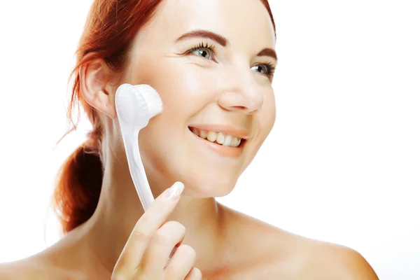 Girl cleaning face with peeling brush — Stock Photo, Image