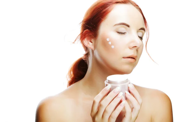 Joven mujer aplicando crema en su cara — Foto de Stock