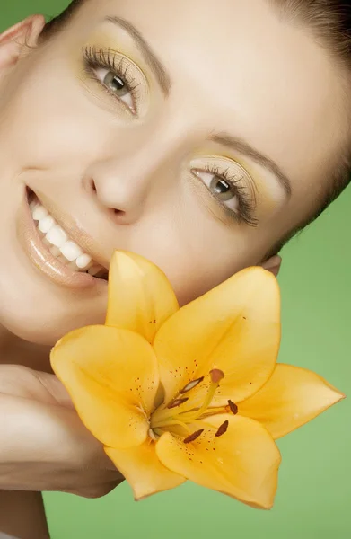 Frau mit gelben Blumen auf grünem Hintergrund — Stockfoto