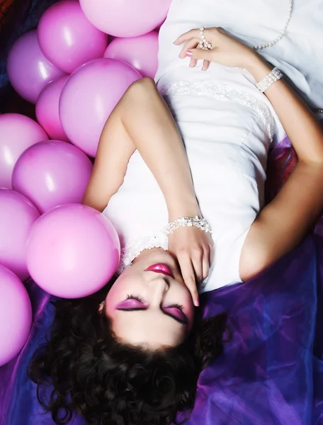 Sleeping woman lying on floor among balloons — Stock Photo, Image