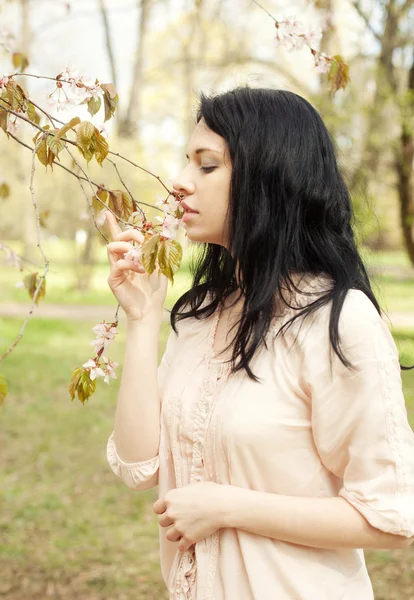 Heureuse jeune femme dans le jardin de fleurs de printemps — Photo