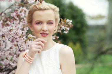 Genç sarışın bir kadın çiçek açan sakura Bahçe