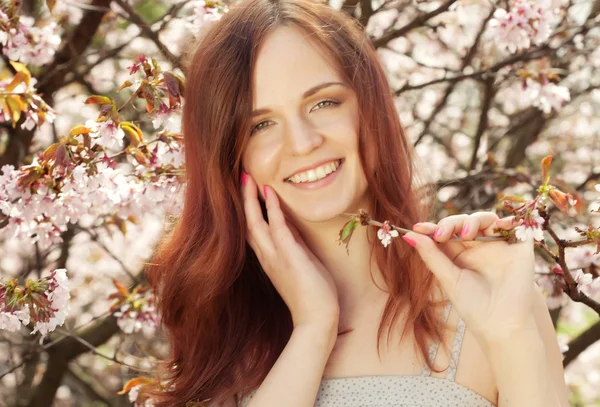 Glad ung kvinna i vår blommor trädgård — Stockfoto