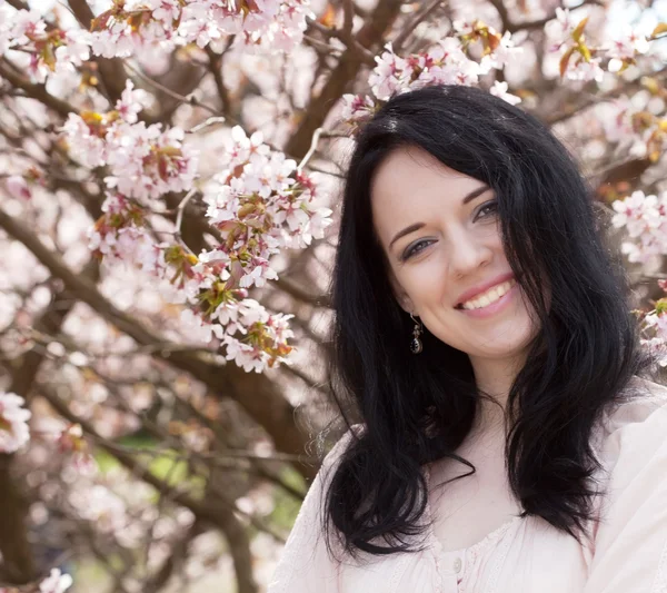 Bella giovane donna in giardino fiorito — Foto Stock