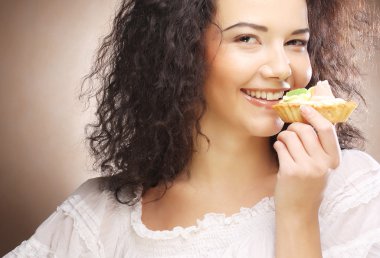 Elinde pasta olan genç bir kadın.