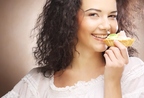 Elinde pasta olan genç bir kadın.