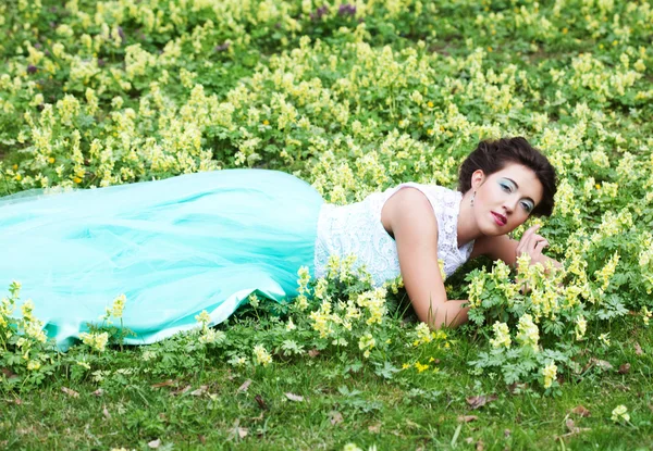 Kvinna i elegance klänning ligger på gräset — Stockfoto