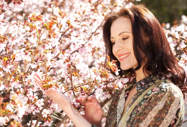 Vacker ung kvinna i blossom trädgård — Stockfoto
