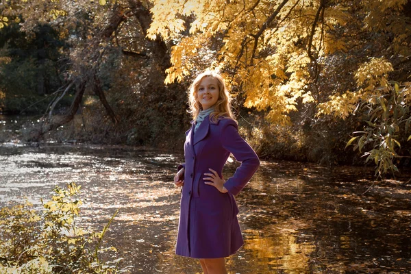 Happy woman  near the river in autumn season — Stock Photo, Image