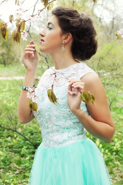 Young woman at spring garden, wearing long dress — Stock Photo, Image