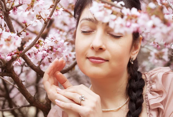 Brunette woman in spring flowers garden — Stock Photo, Image