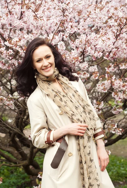 Jovem mulher no jardim de flores de primavera — Fotografia de Stock