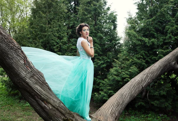 Frau in elegantem Kleid posiert im Garten. — Stockfoto