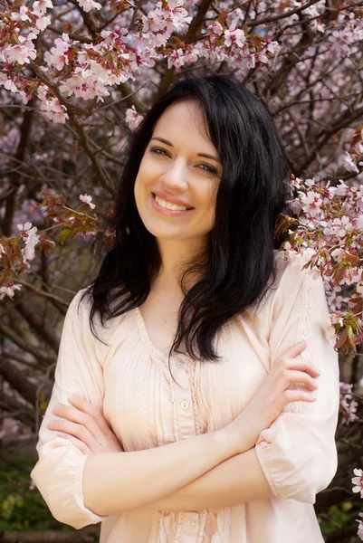 Beautiful young woman in blossom garden — Stock Photo, Image