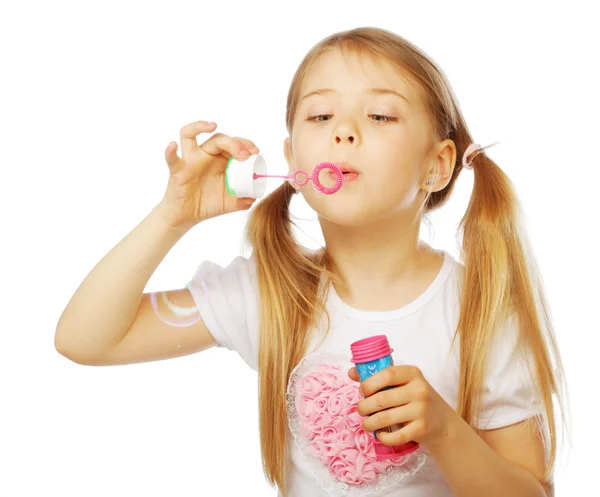 Funny lovely little girl blowing soap bubbles — Stock Photo, Image