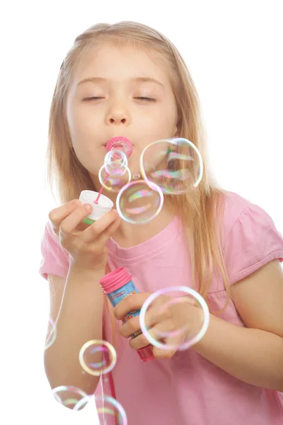 Funny lovely little girl blowing soap bubbles — Stock Photo, Image