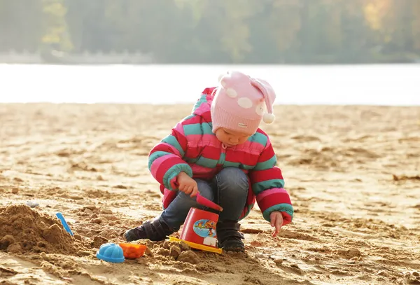 Little girl playing with sand at  beach — Stock Photo, Image