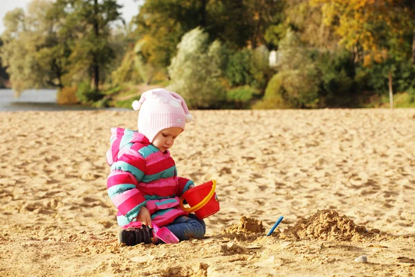 Küçük kız sahilde kum ile oynama — Stok fotoğraf