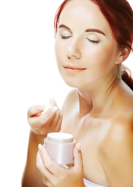 Joven mujer aplicando crema en su cara — Foto de Stock