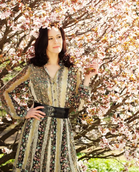 Heureuse jeune femme dans le jardin de fleurs de printemps — Photo