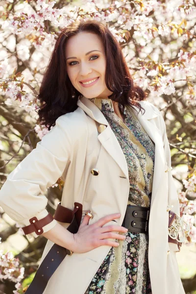 Heureuse jeune femme dans le jardin de fleurs de printemps — Photo