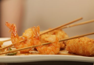 Beyaz tabakta pilavlı ızgara karides.