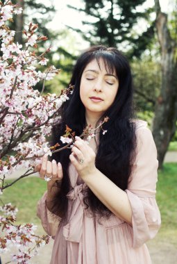 Bahar Çiçek bahçesinde mutlu genç kadın