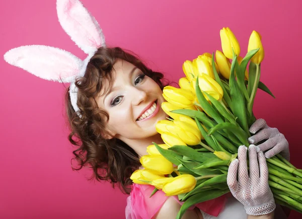 Mulher com orelhas de coelho segurando tulipas amarelas — Fotografia de Stock