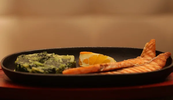 Zalmsteak geserveerd met spinazie — Stockfoto