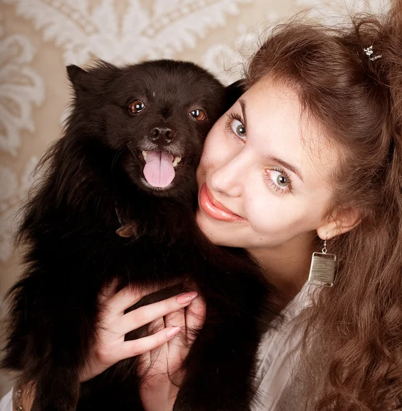 Vrouw bedrijf zwarte hond — Stockfoto