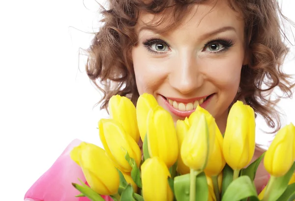 Młoda kobieta uśmiechający się z żółtych tulipanów — Zdjęcie stockowe