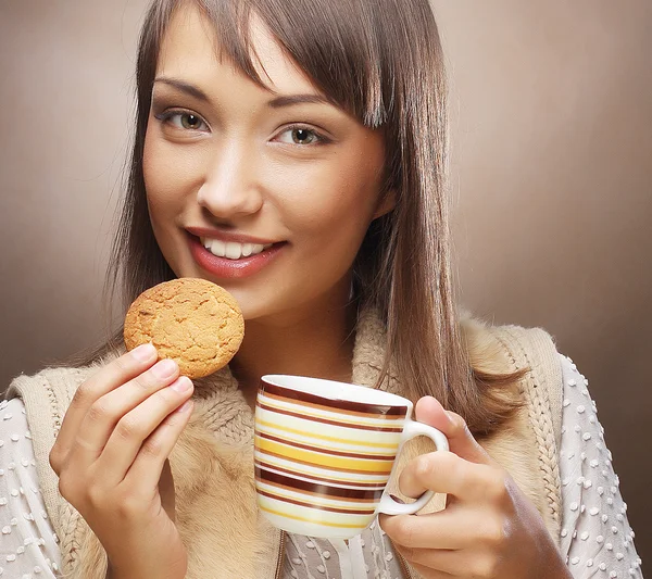 Jonge vrouw met koffie en koekjes — Stockfoto