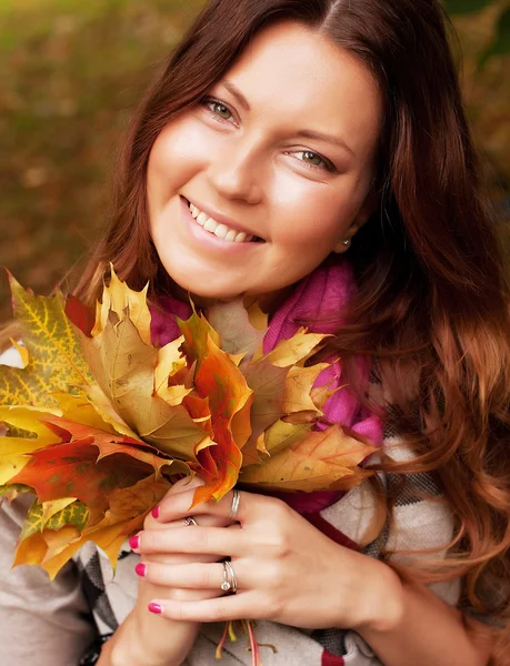 Jeune femme élégante avec des feuilles d'automne — Photo