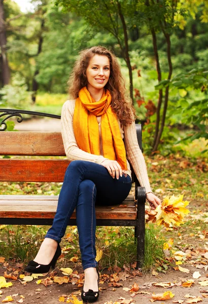 Mujer joven y elegante con hojas de otoño — Foto de Stock