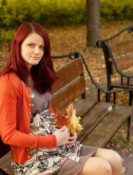 Schöne schwangere Frau geht im Herbstpark spazieren — Stockfoto