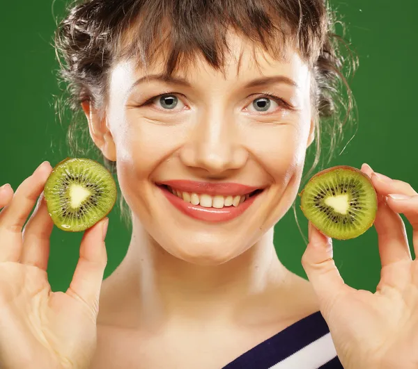 Giovane donna sorridente che tiene kiwi . — Foto Stock