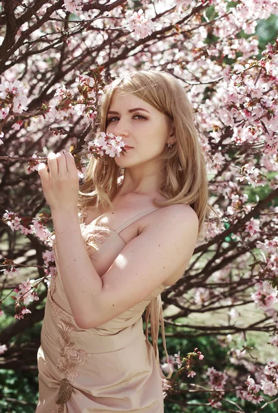 Joven chica rubia en el jardín de flores de primavera —  Fotos de Stock