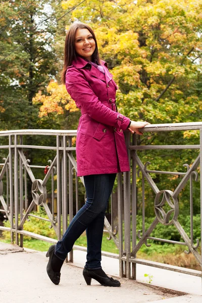 Vrouw op brug in herfstpark — Stockfoto