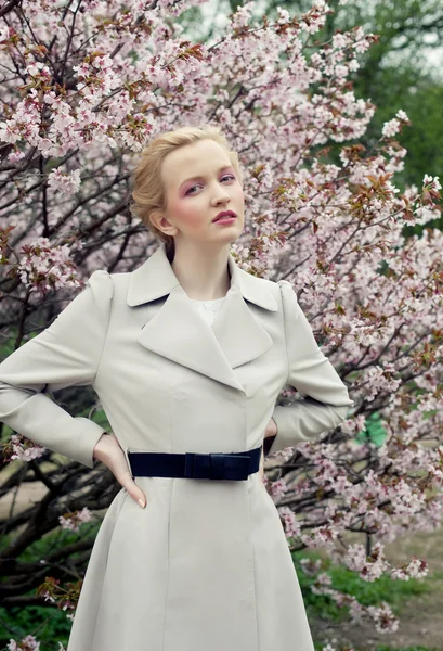 Joven chica rubia en el jardín de flores de primavera —  Fotos de Stock