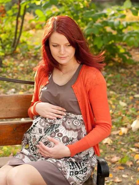 Donna incinta che cammina nel parco autunnale — Foto Stock