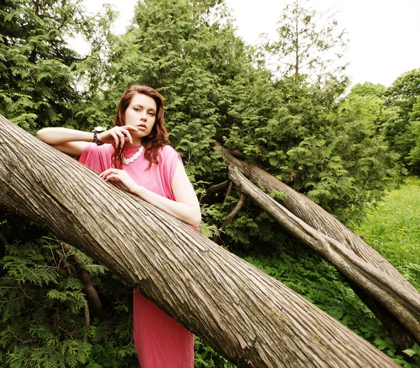 Mladá žena pózuje na stromě — Stock fotografie