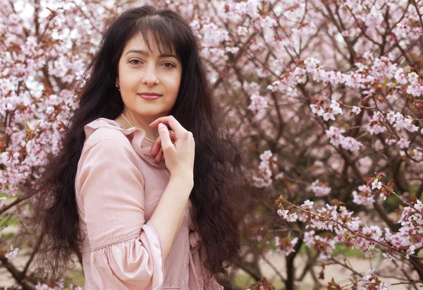 Brunett kvinna i vår blommor trädgård — Stockfoto