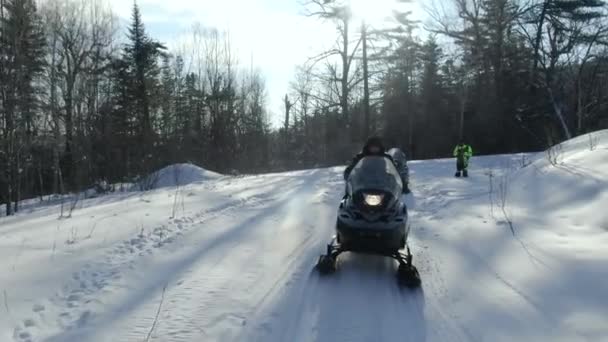 Um grupo de snowmobilers e uma moto de moto de neve. Vista aérea de uma moto de neve que anda no meio de uma fabulosa floresta nevada. evento desportivo. Inverno moto divertido extremo. 4K ProRes 422 HQ — Vídeo de Stock