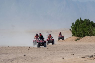 People driving quad bikes during safari trip in Arabian desert not far from Hurghada city, Egypt