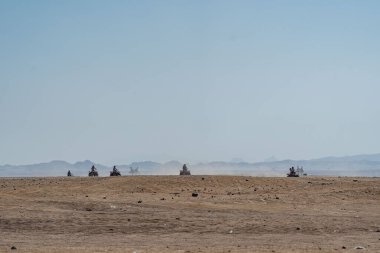 People driving quad bikes during safari trip in Arabian desert not far from Hurghada city, Egypt