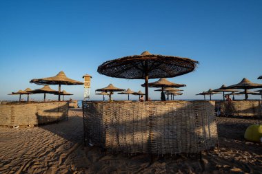 Seascape -view of palm trees, resort beach with sun loungers, umbrellas and the sea. Egypt.