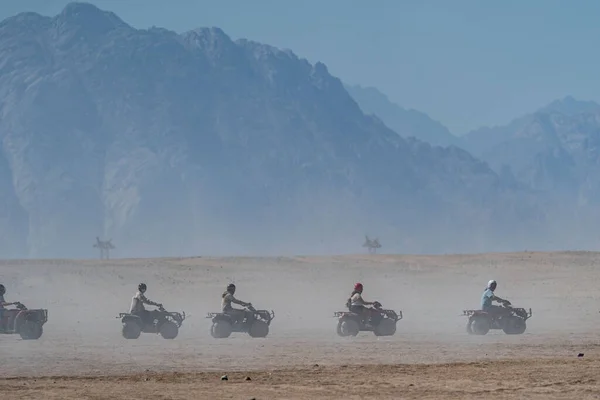 エジプトのフルガダ市から遠くないアラビア砂漠でサファリ旅行中にクワッドバイクを運転する人々 — ストック写真