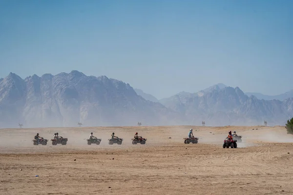 エジプトのフルガダ市から遠くないアラビア砂漠でサファリ旅行中にクワッドバイクを運転する人々 ロイヤリティフリーのストック画像