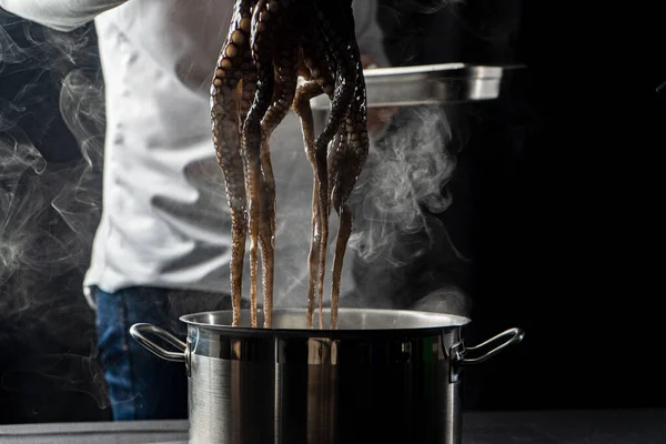 Šéfkuchař připravuje recept chobotnice v kuchyni s kouřem a olejem — Stock fotografie